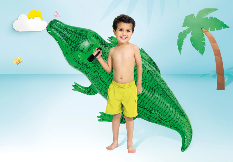 Laad afbeelding in galerijtoner, Een jongen in een gele zwembroek houdt een groene opblaasbare krokodil van Intex vast
