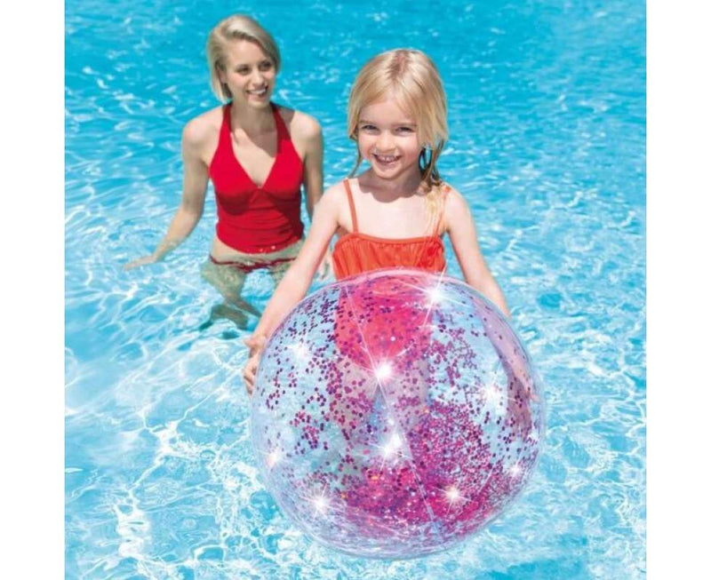 Laad afbeelding in galerijtoner, Een meisje en een moeder spelen in het water met een doorzichtige Intex strandbal met roze glitters
