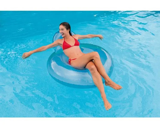 Een vrouw drijft op het water in een opblaasbare blauwe Intex pillow Back lougestoel