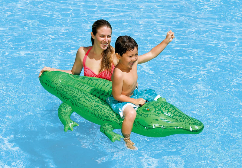 Laad afbeelding in galerijtoner, Een vrouw en een kind zwemmen in het water waar het kind zit op een groene opblaasbare krokodil van Intex
