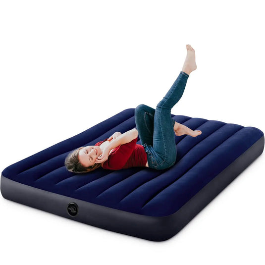 Een vrouw ligt op een donkerblauw Intex Classic Dura Beam twijfelaar luchtbed