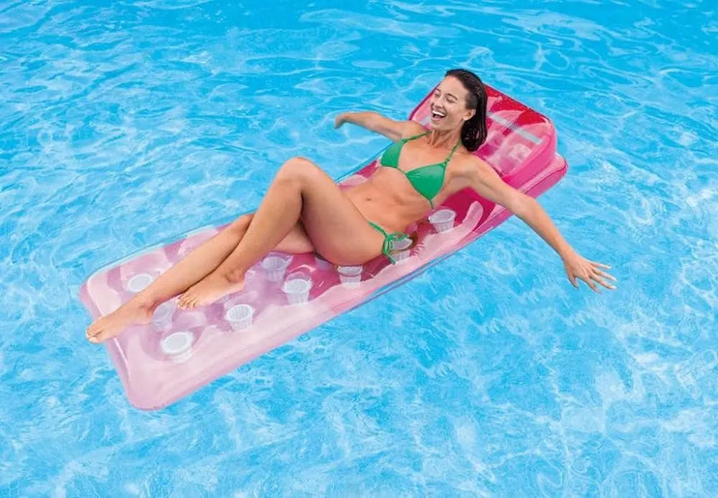 Laad afbeelding in galerijtoner, Vrouw ligt op een roze pocket luchtbed in het water.
