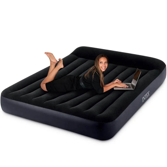 Persoon ligt op een zwarte Intex Pillow Rest Classic tweepersoons luchtbed